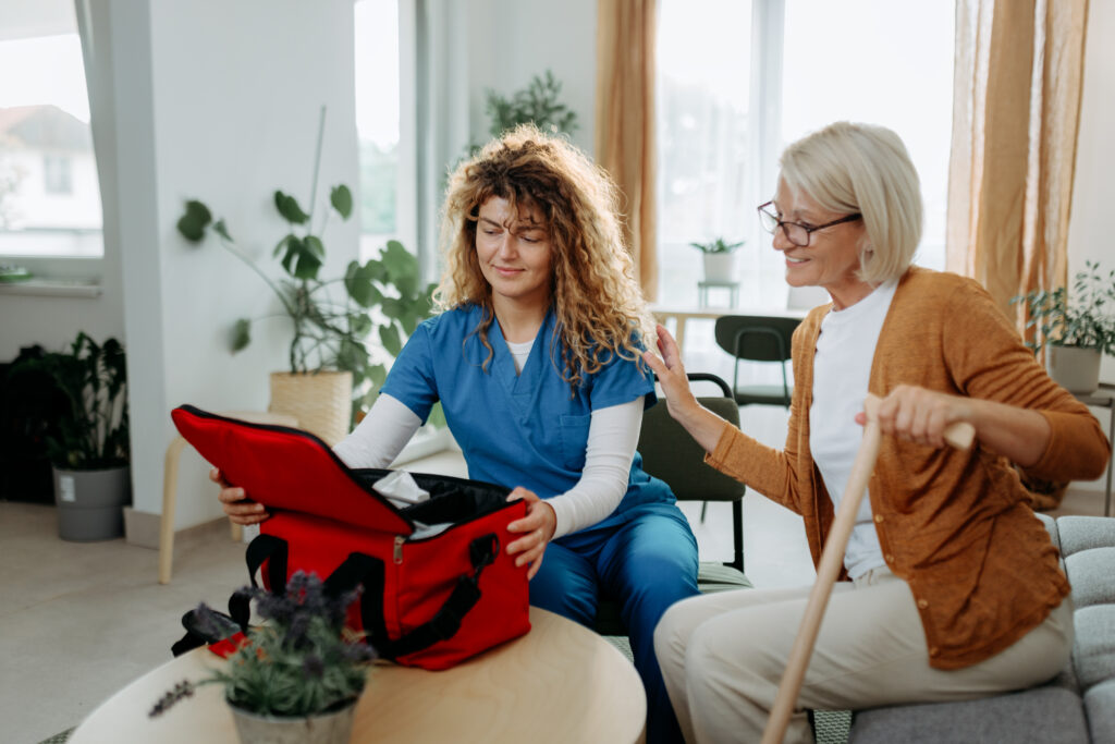 female nurse opening doctor's bag while visiting senior woman